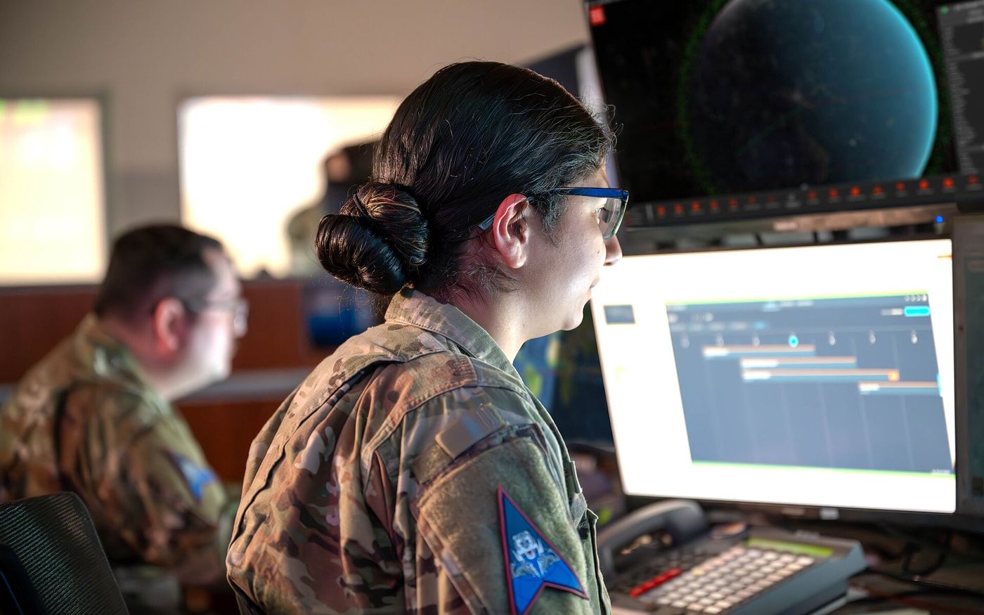Analyst in front of several screens in an operations centre